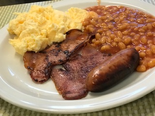 Scrambled eggs, sausage, beans, and ham breakfast in London