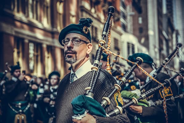 alt = "St. Patrick's Day Bag Pipe Players wearing traditional attire".