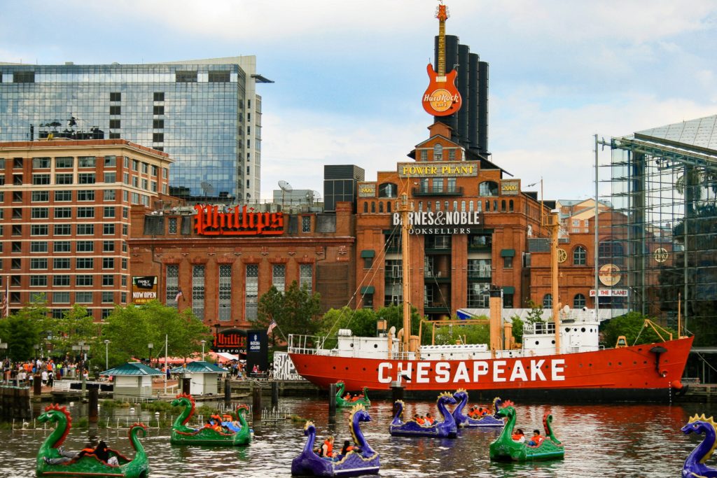 alt txt = "Green and Purple Chessie Dragon Boats, Barnes and Noble, Phillips, Red and White Chesapeake Boat at Baltimore's Inner Harbor."