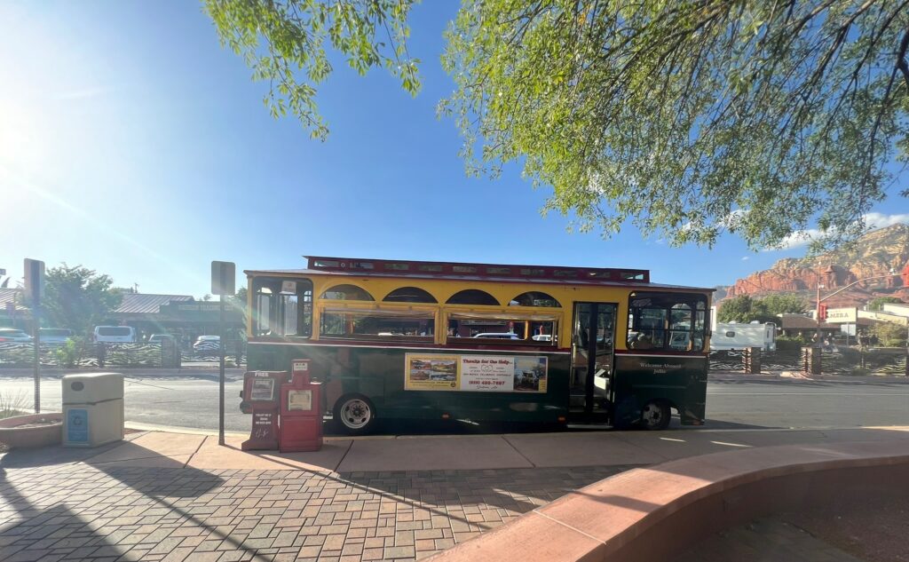 alt txt = "Green. yellow and red trolley in Sedona."
