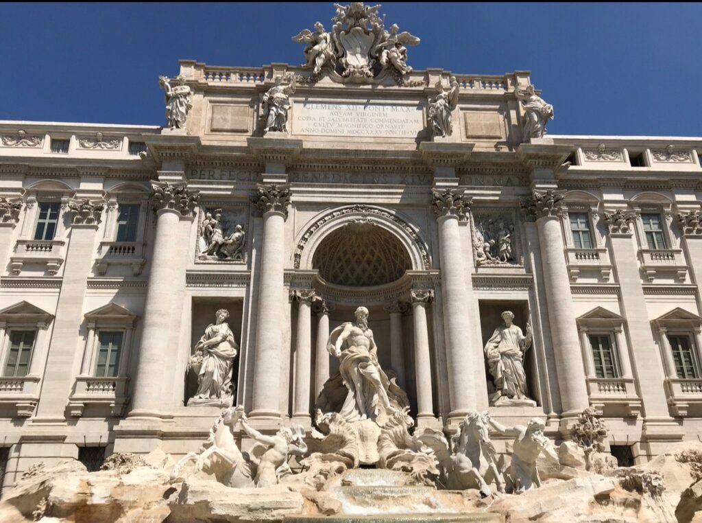 alt txt = "Trevi Fountain in Rome Italy white sculpture with Gods."