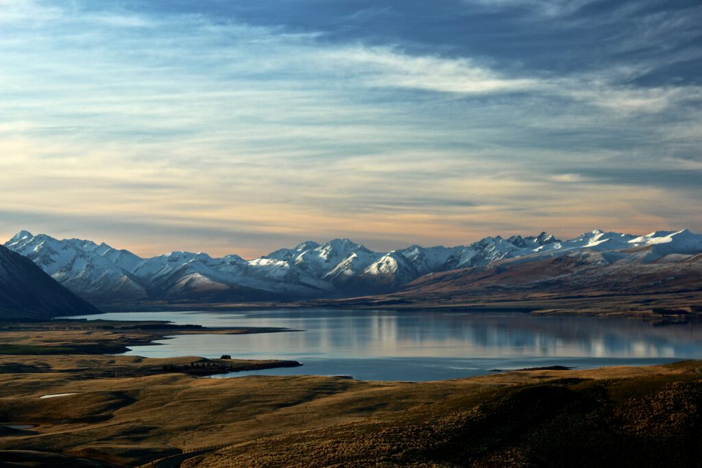 alt txt = "Ocean surrounded by mountains and greenery."