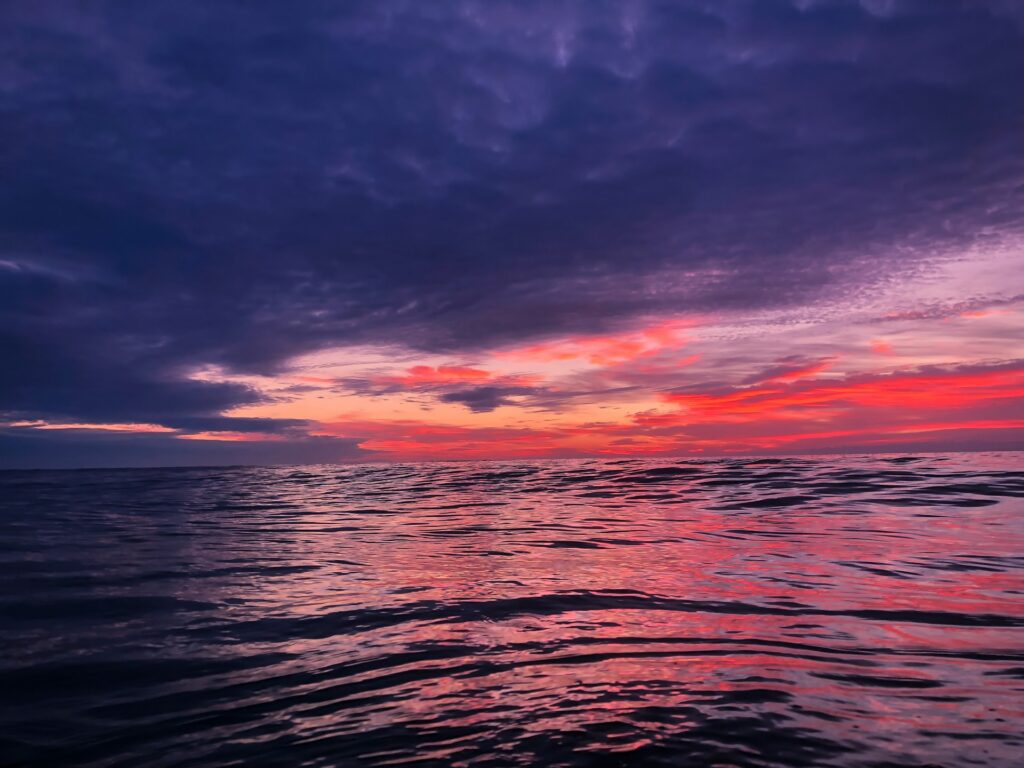 alt txt = "Ocean in the sunset with red orange and purple skies in Wilmington, North Carolina".