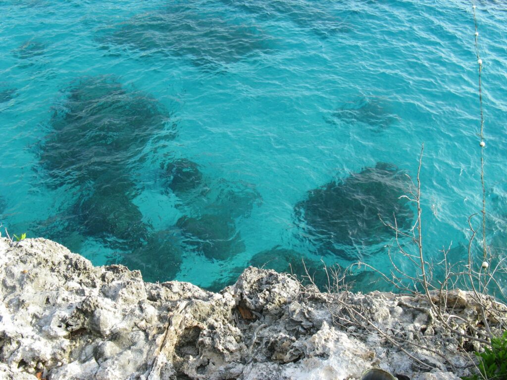 alt txt = "Clear blue water surrounded by rocks".