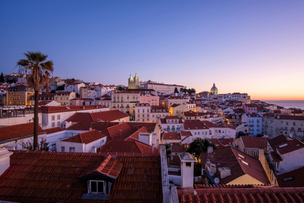 alt txt = "View of red roof buildings under sunrise".
