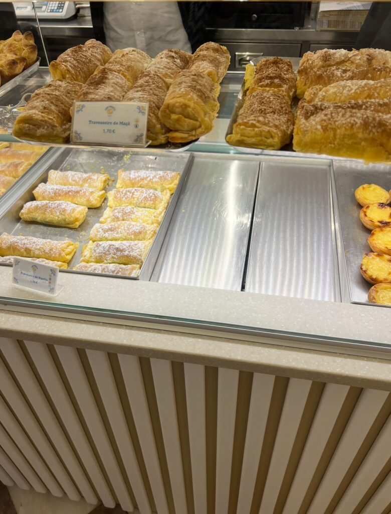 alt txt = "Desserts and pastries in a shop window".