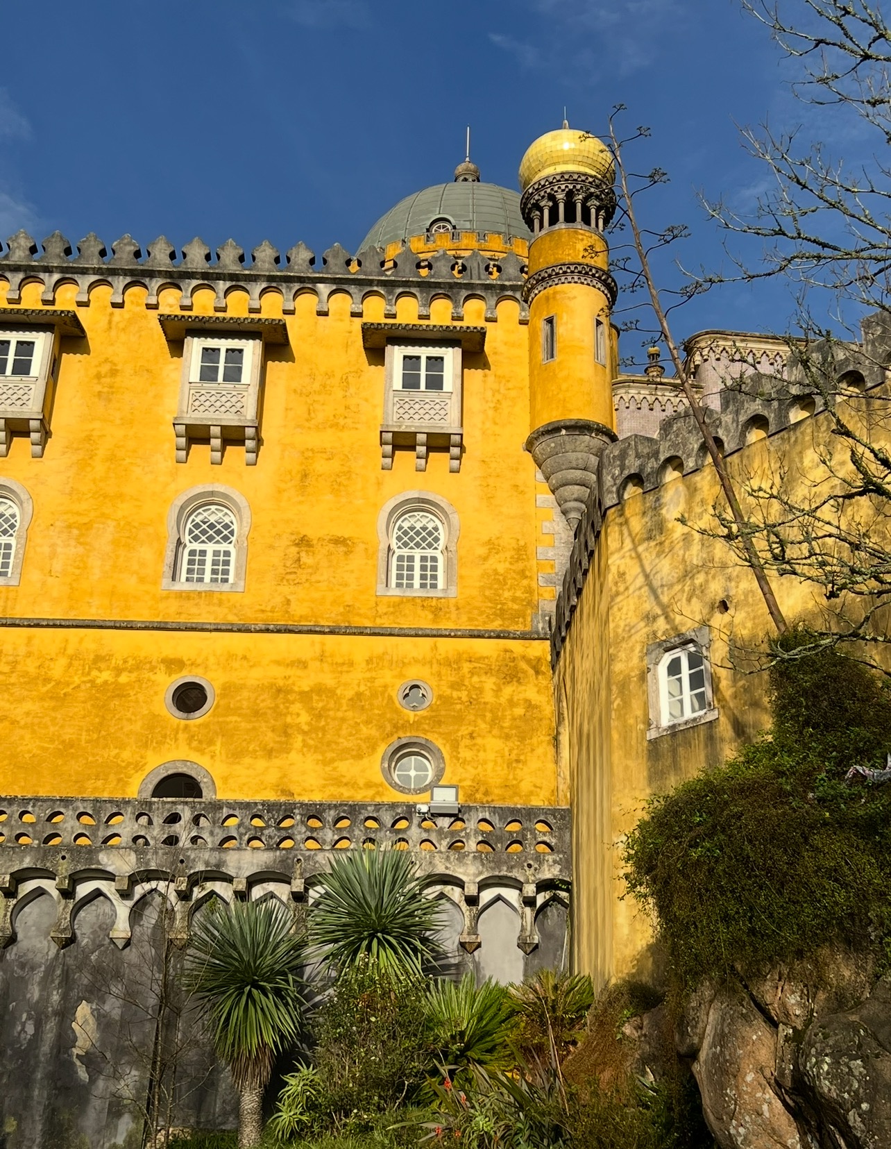 alt txt = "Yellow castle on a hilltop".