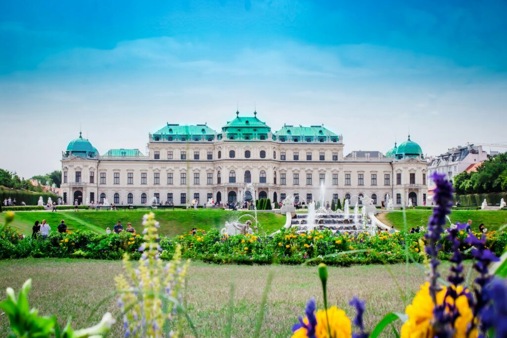 Vienna, AustriaFront view of the Baroque-style Belvedere Palace in Vienna, Austria, with vibrant flower gardens and fountains in the foreground.